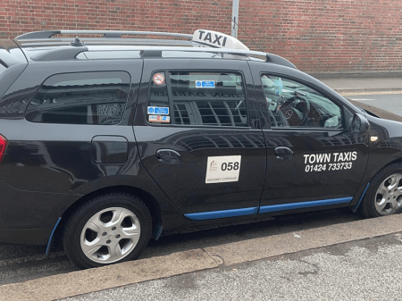 Black taxi with white words saying Town Taxis
