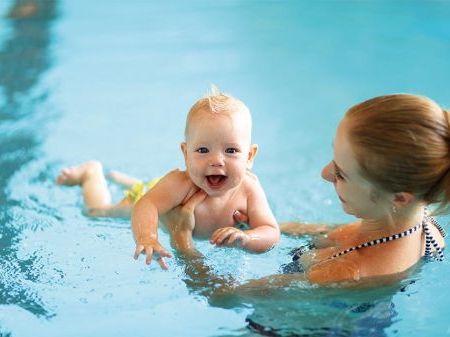 Mum holding baby in swimming pool