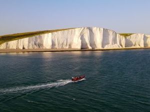 Beachy Head boat trip, red boat is heading towards the red cliffs.