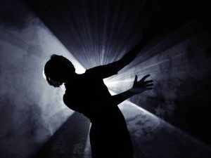 silhouette of someone dancing with light coming from behind