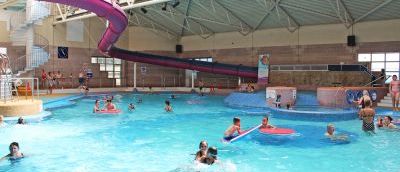 A busy swimming pool with children sitting on big floats