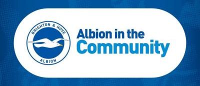 Blue background with the Brighton and Hove Albion logo with a seagull. Next to the logo it has Albion in the community in blue with a white background.