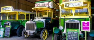 Three cream and green vintage buses