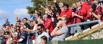 FC Lewes fans celebrate all wearing red tops in support