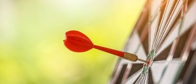 dart-board with a red dart and green background