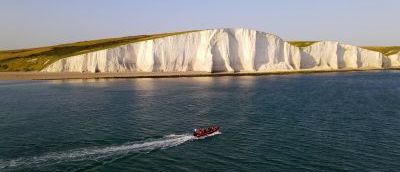 Beachy Head boat trip, red boat is heading towards the red cliffs.