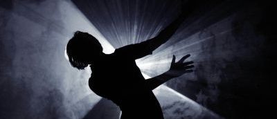 silhouette of someone dancing with light coming from behind