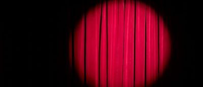 Red stage curtains with a spot light.