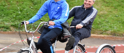 Two people on a bike, riding together